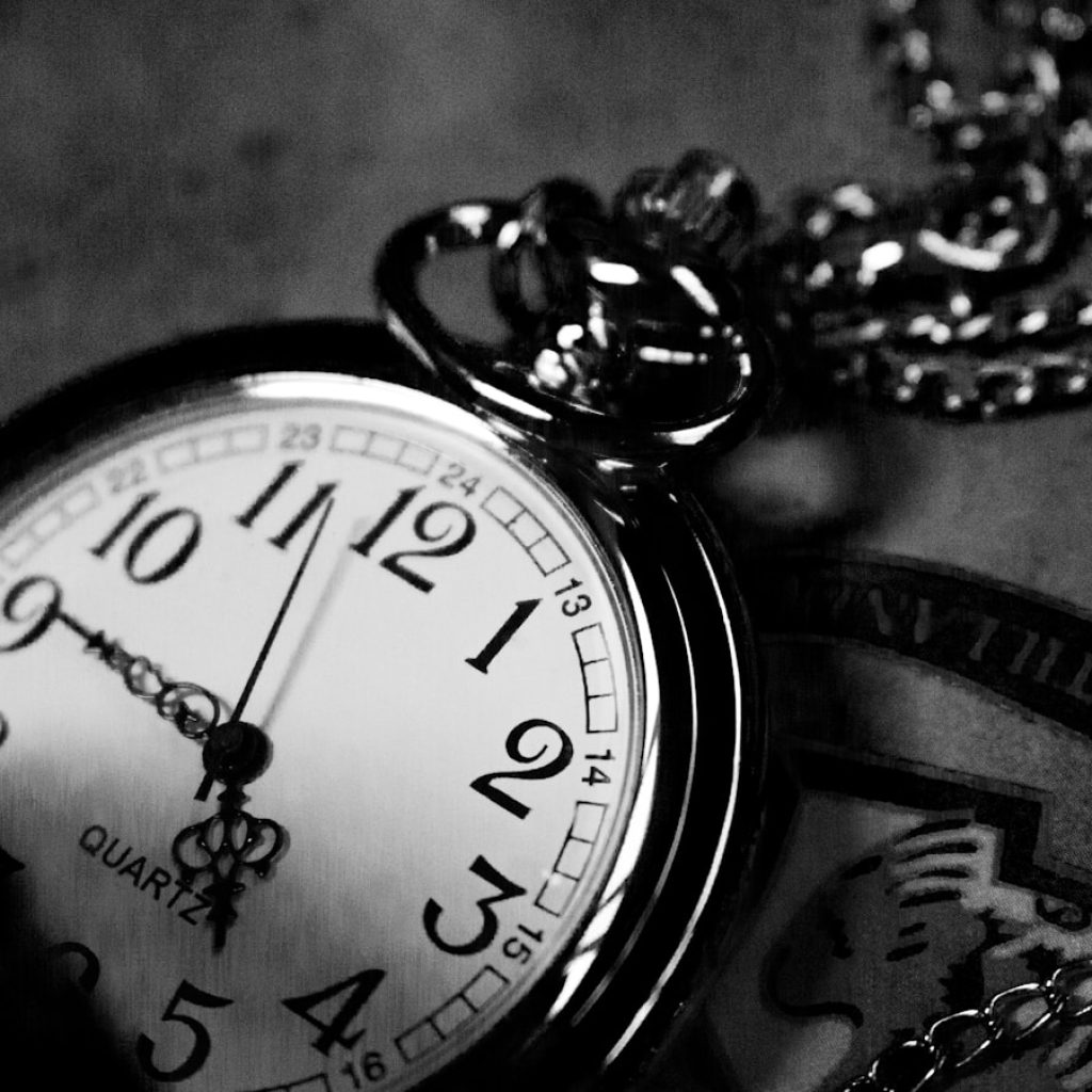 grayscale photography of analog pocket watch